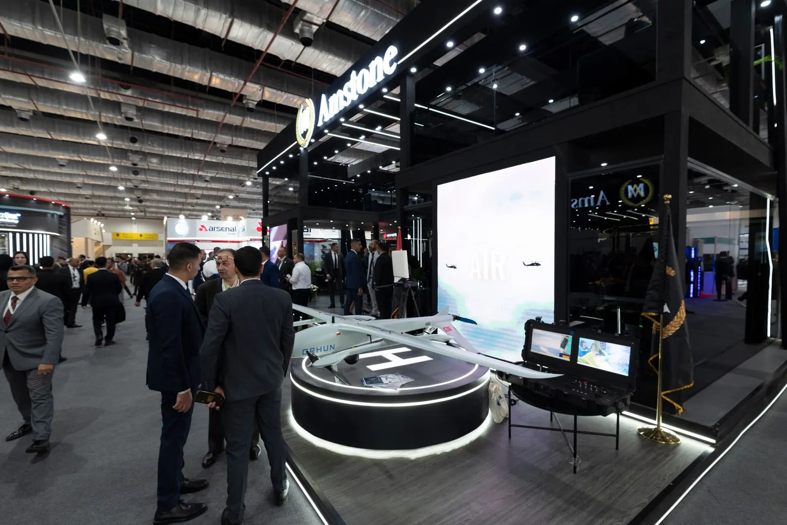 Dark exhibition stand with large screens presenting security technology